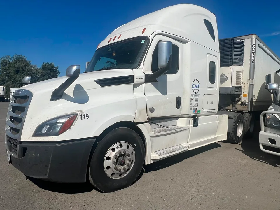 White C M T Transport tractor connected to a refrigerated trailer