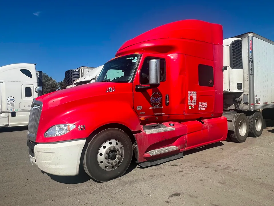Red C M T Transport tractor and refrigerated trailer in the fleet yard