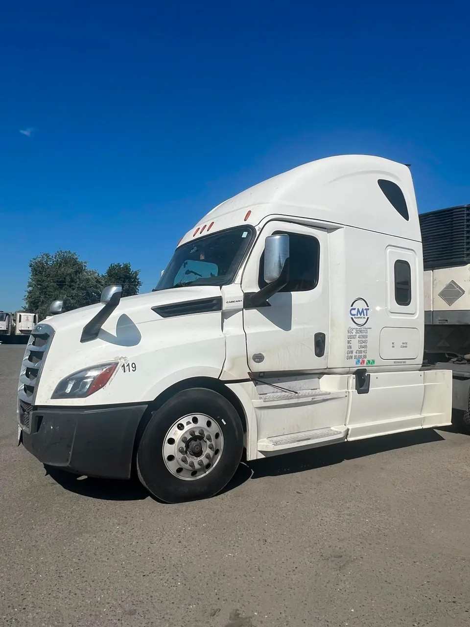 Side view of a white C M T Transport highway tractor