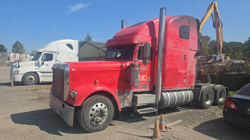 Three-quarter view of a red C M T Transport conventional highway tractor